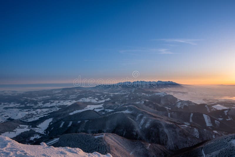 Zimná krajina v horách osvetlených pri východe slnka av pozadí Vysoké Tatry, Slovensko Veľký Choč