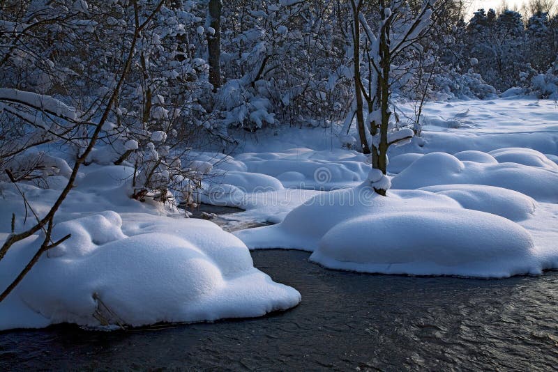 Winter landscape with a river. And pine trees, snow falling, horizontal stock photos