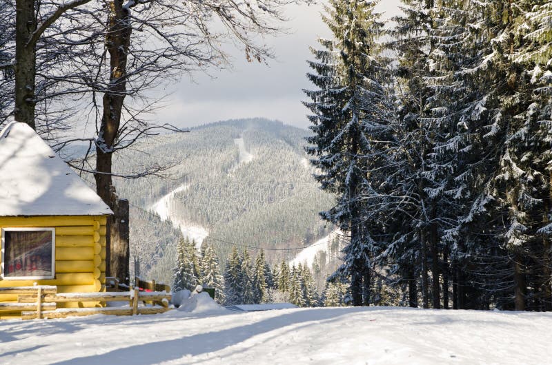 Winter landscape with snow in a mountain valley. Cabin in the woods. Carpathians, Ukraine, Europe.