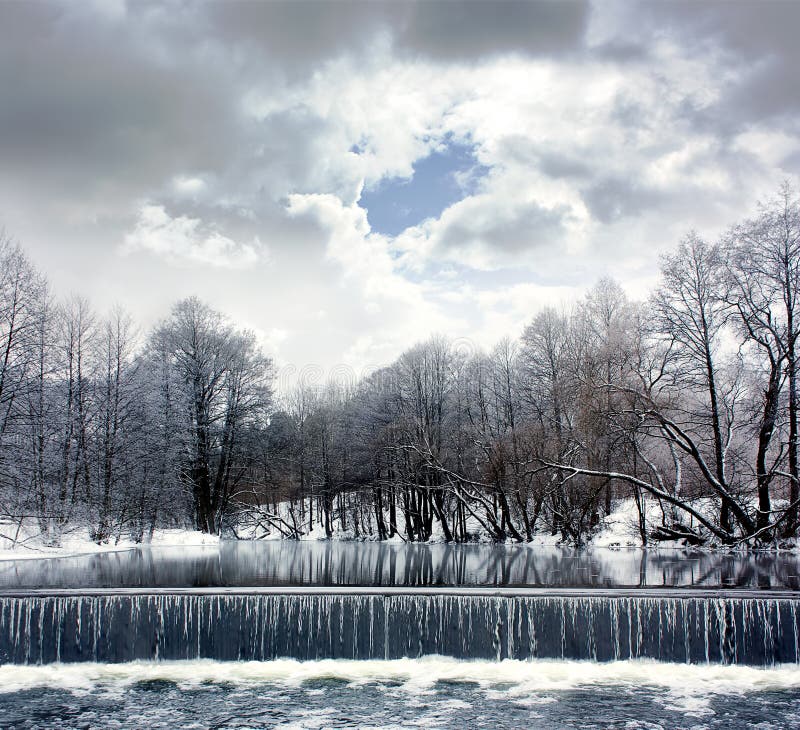 Winter-Landschaft mit Fluss, Wasserfall und Wolken lizenzfreie stockbilder