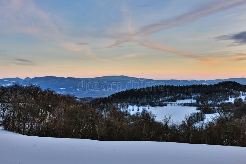Winter mountain landscape at dusk with beautiful hills.