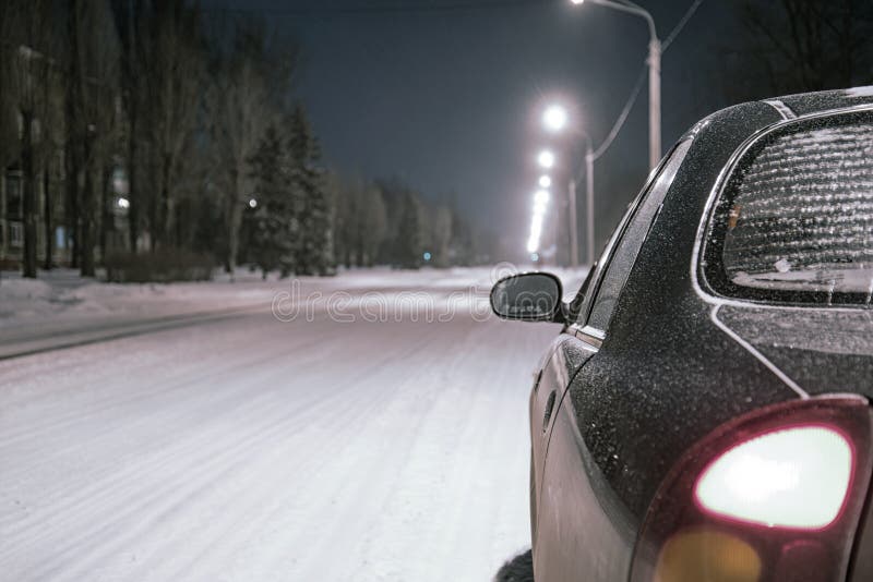 Winter Driving At Snowfall Night Lights Of Car In Snowy Road Stock