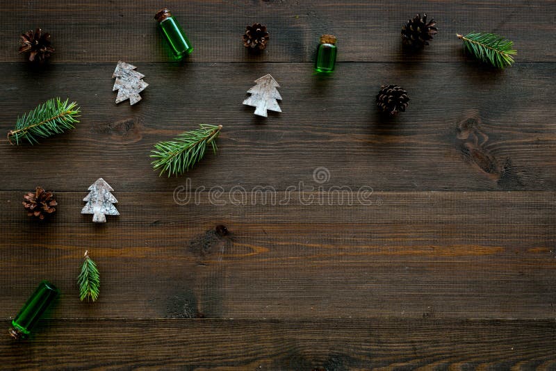 Winter ornament, New Year pattern. Pine sprigs, cones, spruce figure, fir oil on dark wooden background top view copy stock photography Winter ornament, New Year pattern. Pine sprigs, cones, spruce figure, fir oil on dark wooden background top view copy stock photography