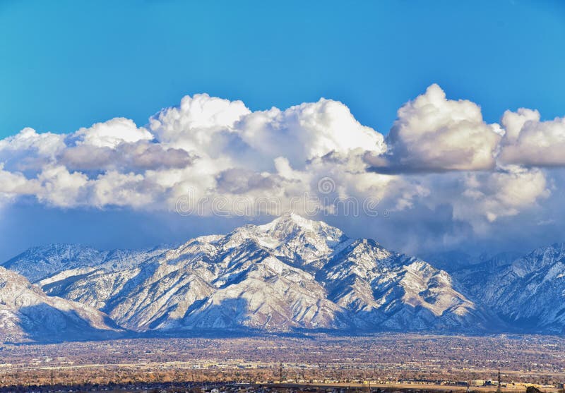 Winter Panoramic view of Snow capped Wasatch Front Rocky Mountains, Great Salt Lake Valley and Cloudscape from the Bacchus Highway