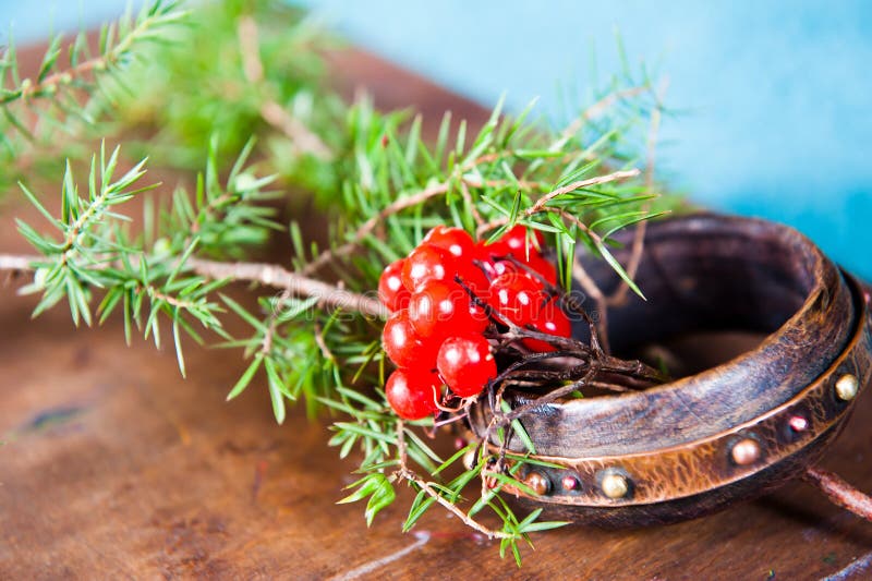 Winter scene with fresh green branches of pine, holly, juniper, cones, star, red berries barberry in natural wooden