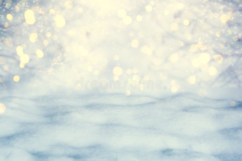 Winter scenic background. Christmas snow landscape with snow drifts and golden lights bokeh. Copy space. Falling snow on nature