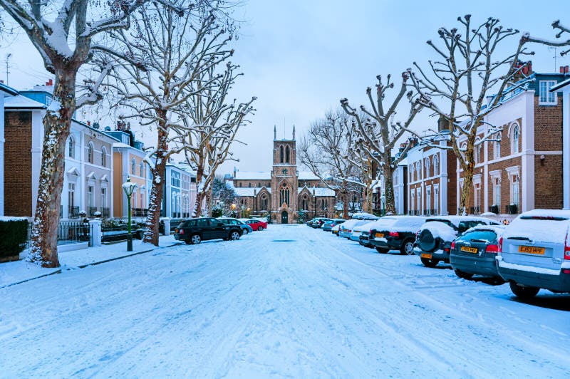Winter Street, London - England. Snow covered, cosy street in Holland Park, London. (St James’s Church in the middle royalty free stock photography Winter Street, London - England. Snow covered, cosy street in Holland Park, London. (St James’s Church in the middle royalty free stock photography