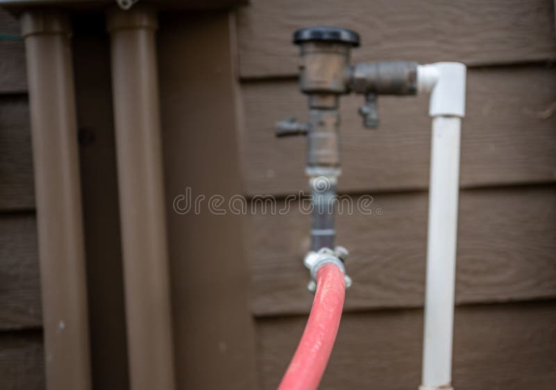Winterizing a residential irrigation system by using a compressor and forced air to blow the lines empty. stock photography