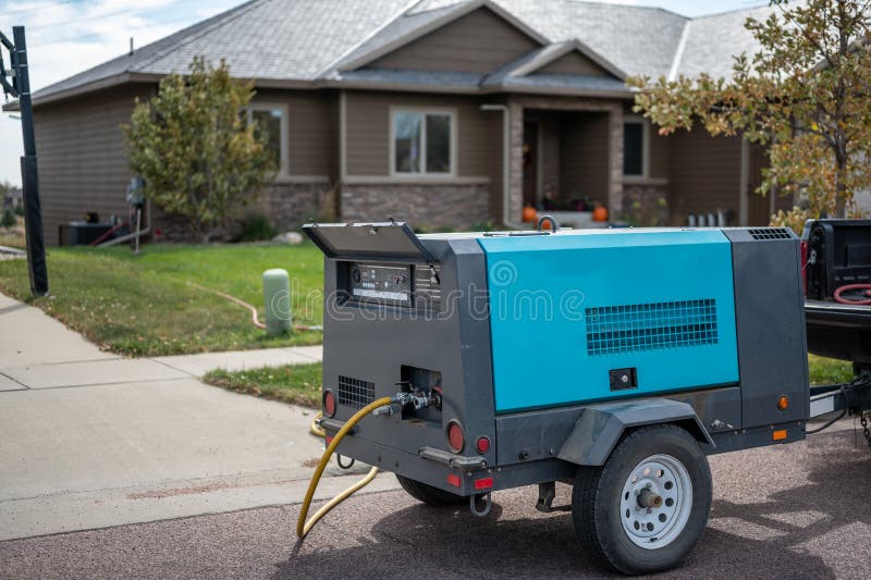 Winterizing a residential irrigation system by using a compressor and forced air to blow the lines empty. royalty free stock photography