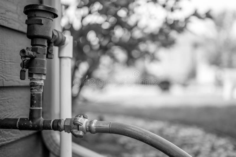 Winterizing a residential irrigation system by using a compressor and forced air to blow the lines empty. stock photography