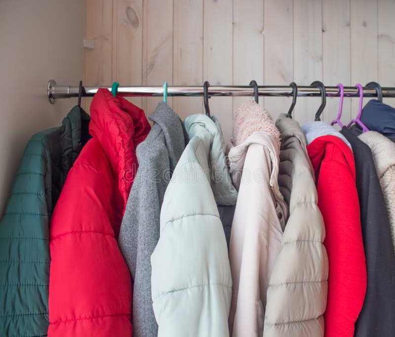 Winterkleidung in einem Schrank auf einem Kleiderbügel. Reinigungswinterkleidung bis nächste Saison