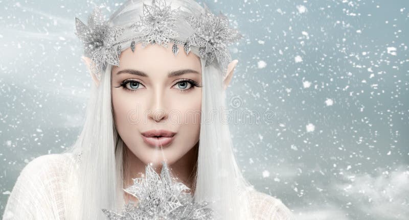 Winterkoningin. prachtige vrouw met sneeuwkoningin die magische ijskuiken blaast. sprookjesconcept voor kerstmis