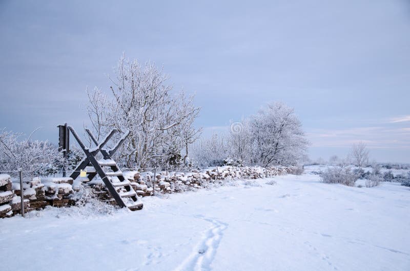 Winterland with a stile at a stone wall