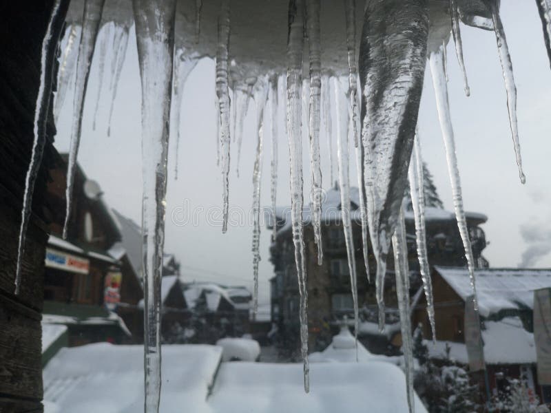 Winterräder auf einem Fensterrahmen mit schönem Blick auf einen Bergwald von einem Skigebiet lizenzfreie stockbilder Winterräder auf einem Fensterrahmen mit schönem Blick auf einen Bergwald von einem Skigebiet lizenzfreie stockbilder