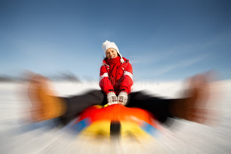 Caucasian woman is sliding fast downhill on an inner tube. Caucasian woman is sliding fast downhill on an inner tube