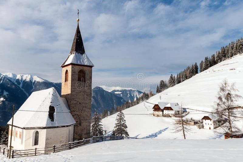 A wintertime view of a small church with a tall steeple