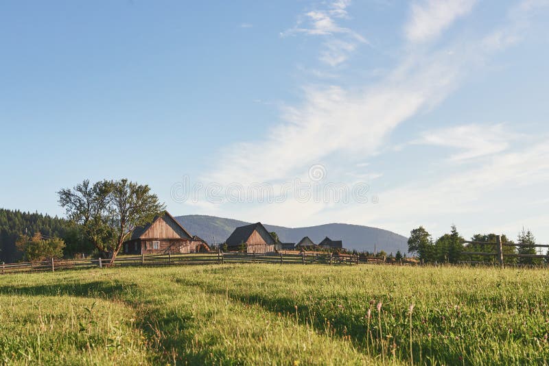 Wioska domy na wzgórzach z zielonymi łąkami w letnim dniu Dom bacy w górach w carpathian zdjęcia stock Wioska domy na wzgórzach z zielonymi łąkami w letnim dniu Dom bacy w górach w carpathian zdjęcia stock