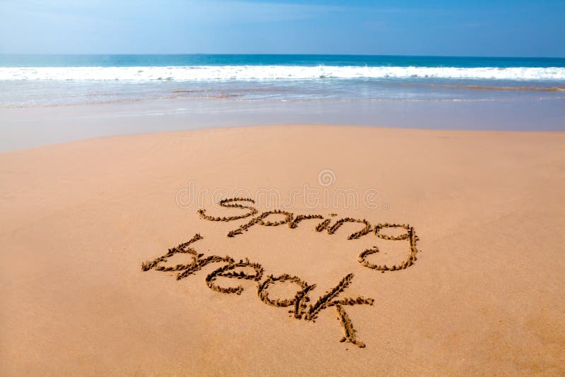 Words spring break written in sand on a tropical beach, with sea in background. Words spring break written in sand on a tropical beach, with sea in background