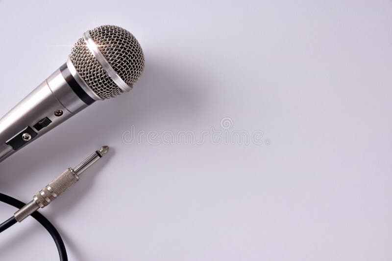 Wired microphone with jack connector on white table. Close up. Top view. Horizontal composition. Wired microphone with jack connector on white table. Close up. Top view. Horizontal composition