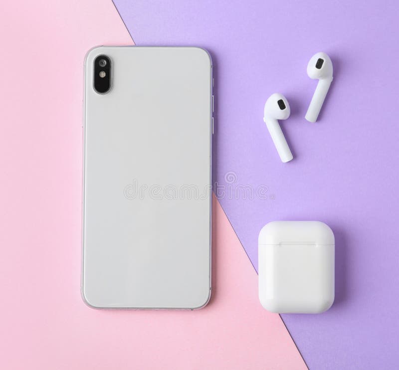 Wireless earphones,  phone and charging case on color background, flat lay