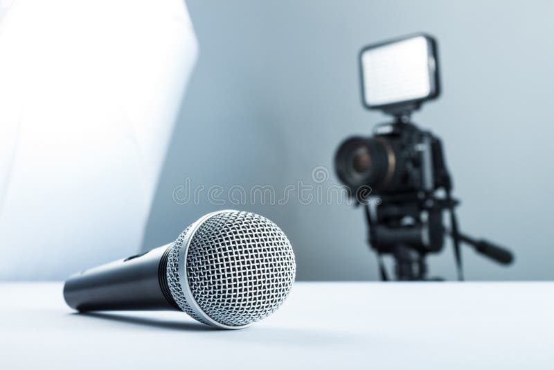A wireless microphone lying on a white table against the background of the DSLR camera to led light royalty free stock photo A wireless microphone lying on a white table against the background of the DSLR camera to led light royalty free stock photo