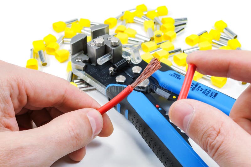 Wires stripper in master hand and cord end terminals on a white background stock image