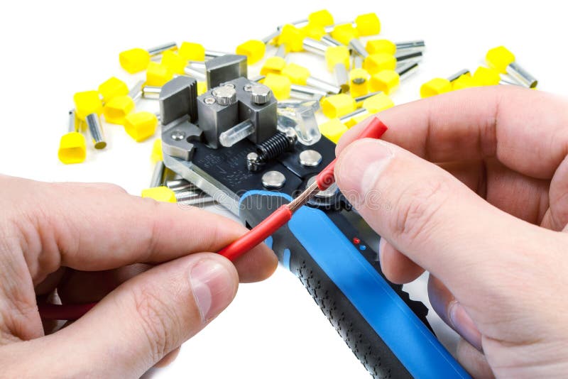 Wires stripper in master hand and cord end terminals on a white background royalty free stock image