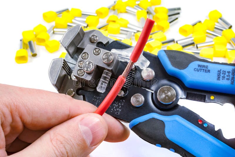 Wires stripper in master hand and cord end terminals on a white background royalty free stock image