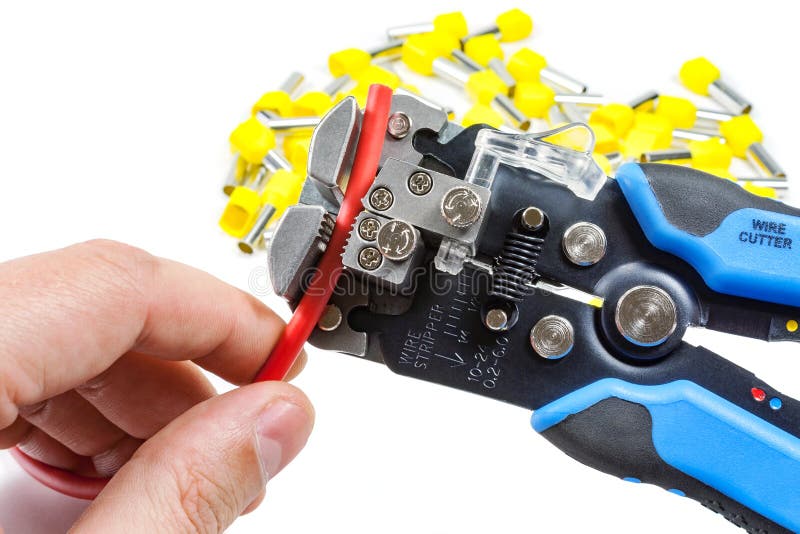 Wires stripper in master hand and cord end terminals on a white background royalty free stock photo