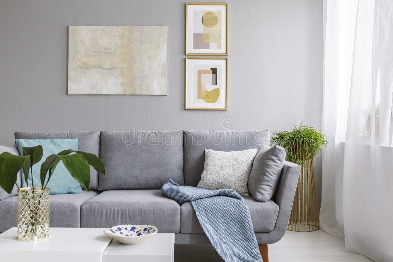 Wirkliches Foto eines grauen Sofas, das in einem stilvollen Wohnzimmer inte steht