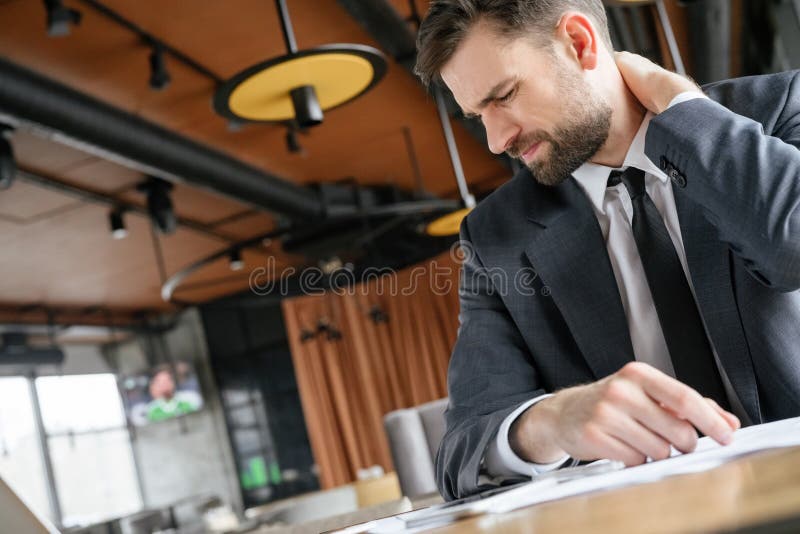 Wirtschaftler auf Business-Lunch am Restaurant, das Halsmuskelschmerzen berührend sitzt stockfoto Wirtschaftler auf Business-Lunch am Restaurant, das Halsmuskelschmerzen berührend sitzt stockfoto