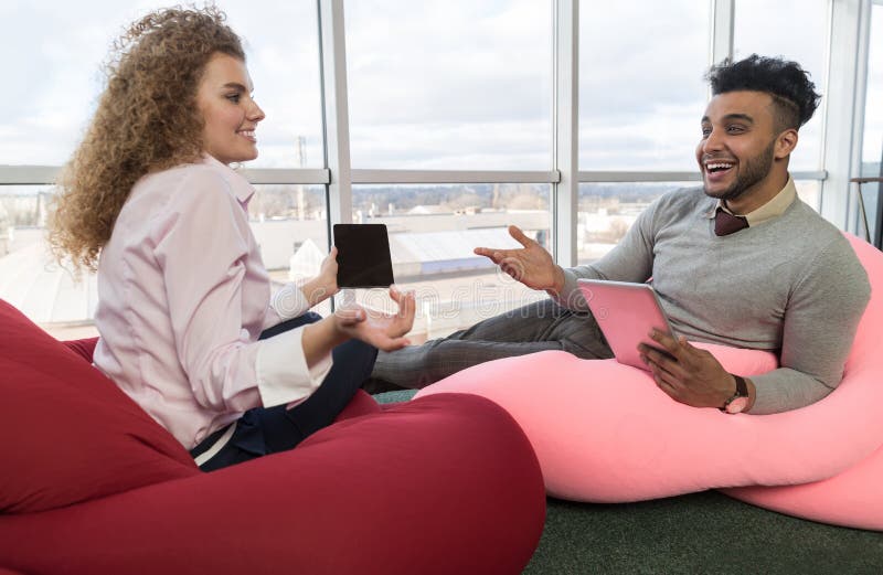 Wirtschaftler-Paar-Kommunikation Coworking-Mitte-Geschäft Team Coworkers Sitting im vorderen großen panoramischen Fenster lizenzfreies stockbild Wirtschaftler-Paar-Kommunikation Coworking-Mitte-Geschäft Team Coworkers Sitting im vorderen großen panoramischen Fenster lizenzfreies stockbild