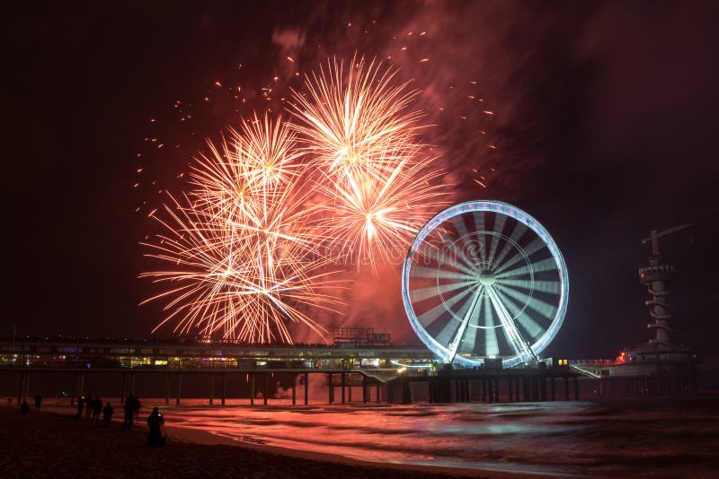 Wirujący Ferris koło z fajerwerkami przy molem Scheveningen, blisko Haga, holandie obraz royalty free Wirujący Ferris koło z fajerwerkami przy molem Scheveningen, blisko Haga, holandie obraz royalty free