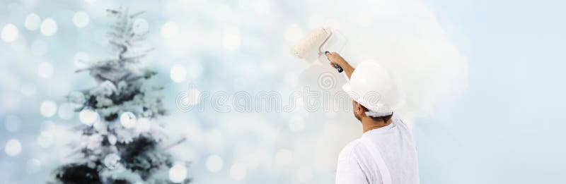 Wish a Merry Christmas concept, painter with roller painting a C stock photo Wish a Merry Christmas concept, painter with roller painting a C stock photo