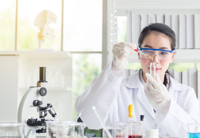 Wissenschaftlerschönheitsforschung und medizinische Chemikalienprobe des Tropfens im Reagenzglas am Labor
