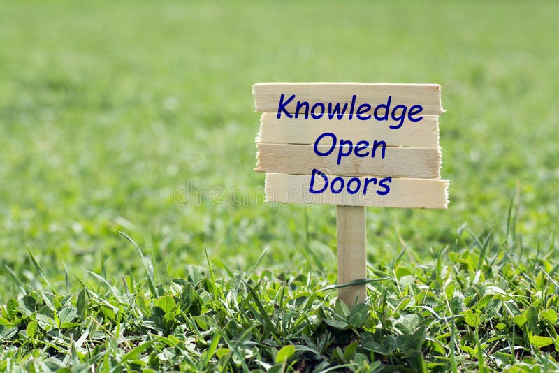 Knowledge open doors wooden sign in grass,blur background. Knowledge open doors wooden sign in grass,blur background
