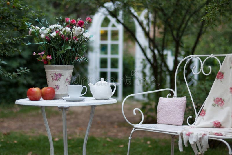 Wit die porselein voor thee of koffie op lijst in de tuin over achtergrond van de onduidelijk beeld de groene aard, ondiepe diept royalty-vrije stock afbeelding Wit die porselein voor thee of koffie op lijst in de tuin over achtergrond van de onduidelijk beeld de groene aard, ondiepe diept royalty-vrije stock afbeelding
