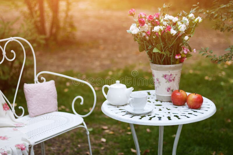 Wit die porselein voor thee of koffie op lijst in de tuin over achtergrond van de onduidelijk beeld de groene aard wordt geplaats royalty-vrije stock foto Wit die porselein voor thee of koffie op lijst in de tuin over achtergrond van de onduidelijk beeld de groene aard wordt geplaats royalty-vrije stock foto