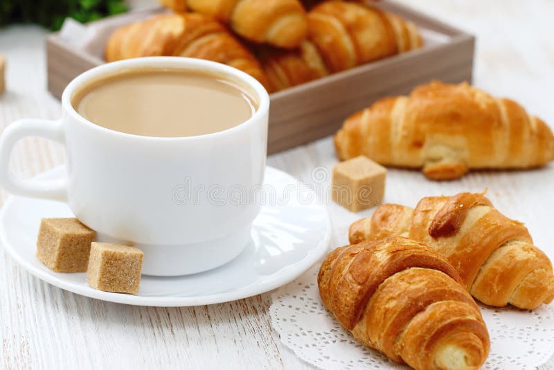 Wit koffie en croissant voor ontbijt royalty-vrije stock afbeeldingen Wit koffie en croissant voor ontbijt royalty-vrije stock afbeeldingen