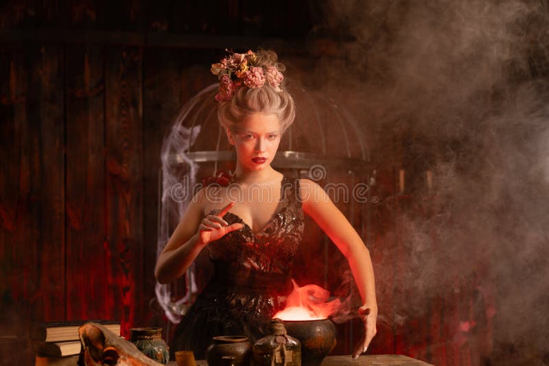 Witch with cauldron conjuring magic spell royalty free stock photo