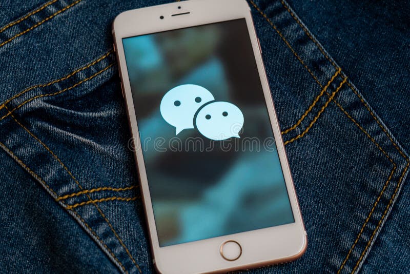 Witte iPhone met embleem van sociale media WeChat van China op het scherm Sociaal media pictogram stock foto Witte iPhone met embleem van sociale media WeChat van China op het scherm Sociaal media pictogram stock foto