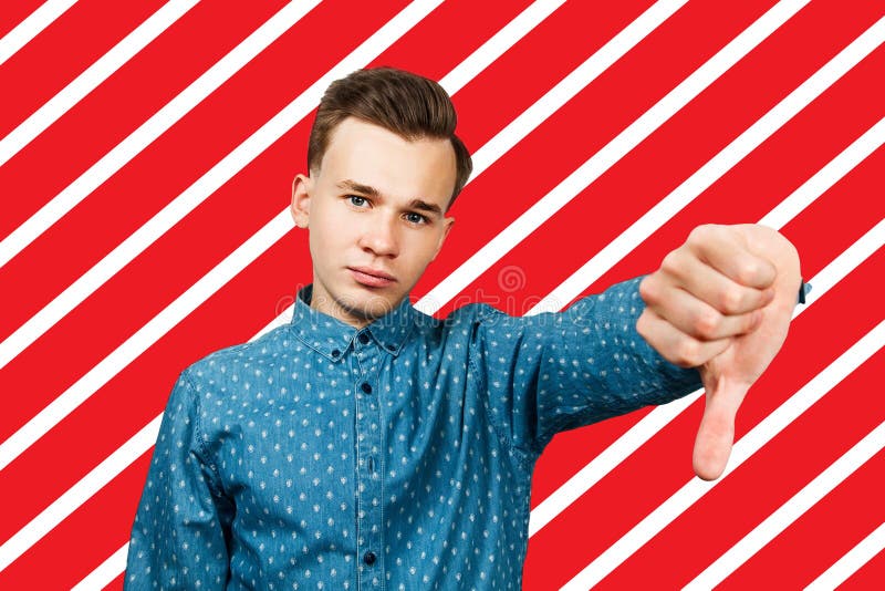 Witte jongeman toont duim naar beneden gekleed in blauw shirt royalty-vrije stock foto's Witte jongeman toont duim naar beneden gekleed in blauw shirt royalty-vrije stock foto's
