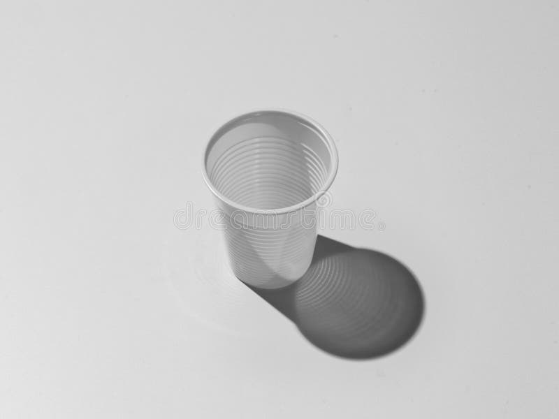 Witte plastic kop op de grijze achtergrond stock fotografie Witte plastic kop op de grijze achtergrond stock fotografie