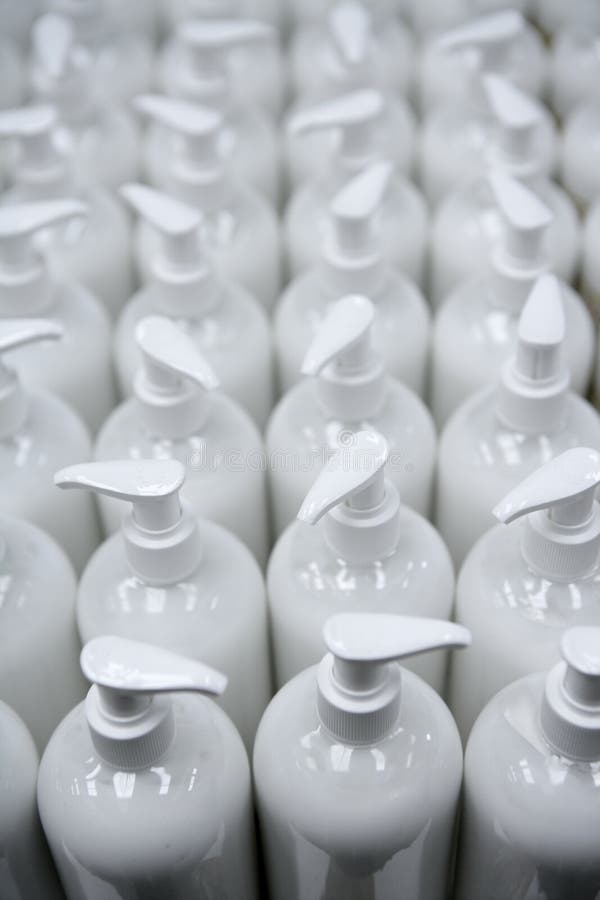 Witte plastic zeepflessen in rijenlopende band stock afbeeldingen Witte plastic zeepflessen in rijenlopende band stock afbeeldingen
