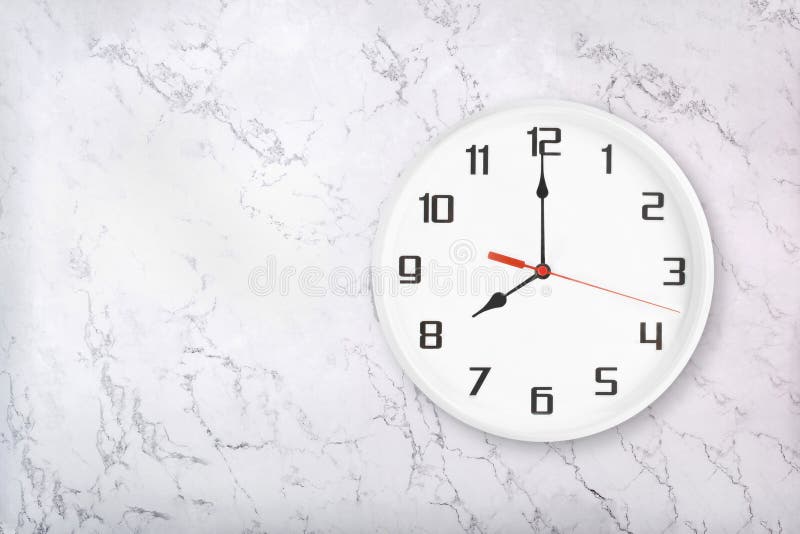 Witte ronde wandklok op witte, natuurlijke marmerachtergrond Acht uur stock afbeelding Witte ronde wandklok op witte, natuurlijke marmerachtergrond Acht uur stock afbeelding