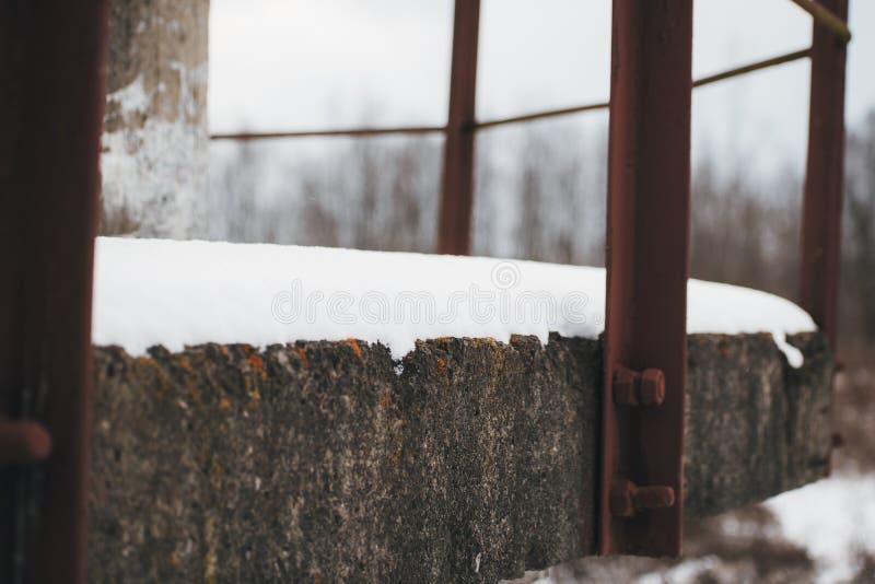 white snow on a concrete balcony with a metal railing. white snow on a concrete balcony with a metal railing.