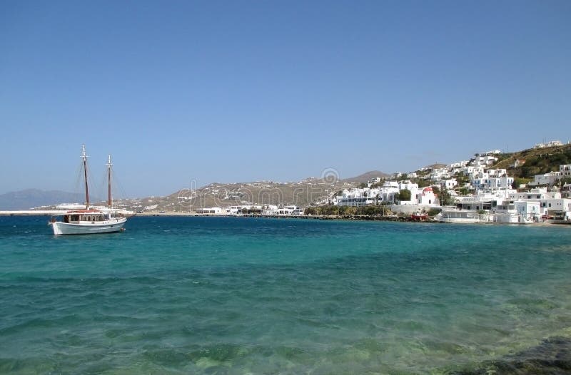 Witte vissersboot en weinig stad tussen de blauwe hemel en het blauwe overzees, Mykonos-Eiland royalty-vrije stock afbeeldingen Witte vissersboot en weinig stad tussen de blauwe hemel en het blauwe overzees, Mykonos-Eiland royalty-vrije stock afbeeldingen
