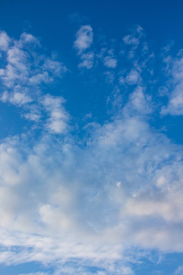 Witte zachte wolken in blauwe lucht, verticaal formaat_