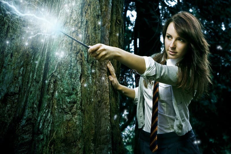 Teenage wizard girl with magic wand casting spells in a enchanted fantasy forest