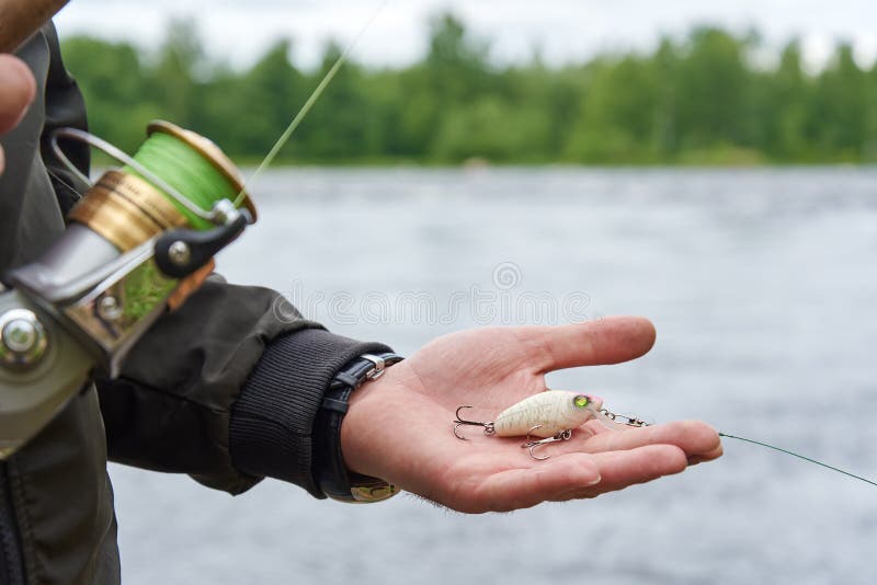 Wobbler in Manâ€™s Hand and Spinning Rod Reel Against Rapid River Stock  Photo - Image of reed, lure: 175694258